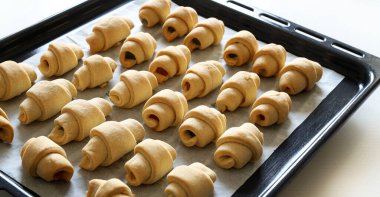 Ay çöreği. Fırın pişirme tepsisinde küçük kruvasanlar pişirdi. Cornulee, geleneksel Romanya tatlısı. Genel Görünüm.