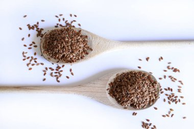 Beyaz arka planda izole edilmiş keten tohumu tahta kaşık. Keten tohumları lif, omega-3 yağ asitleri ve lingnanlar açısından zengindir. Sağlıklı gıda konsepti. Boşluğu kopyala.