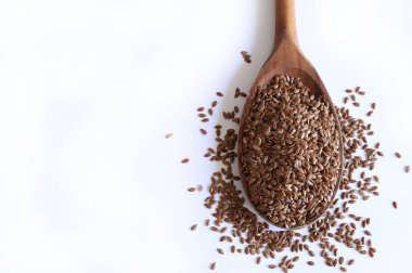 Beyaz arka planda izole edilmiş keten tohumu tahta kaşık. Keten tohumları lif, omega-3 yağ asitleri ve lingnanlar açısından zengindir. Sağlıklı gıda konsepti. Boşluğu kopyala.