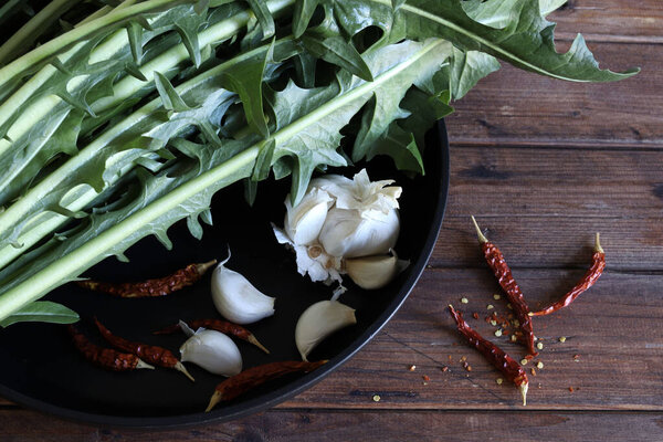 Bunch chicory Catalonia, garlic and pepper isolated on a wooden background. Fresh Italian vegetable. Healthy and vegetarian food. Directly above.