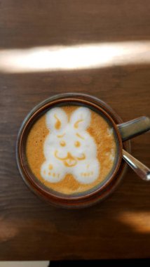 Kahve fincanında latte sanatıyla birlikte sıcak latte sanatı.