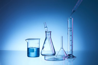 Mavi sıvılı laboratuvar şişesi.