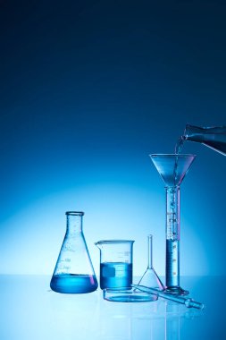 Mavi sıvılı laboratuvar şişesi.