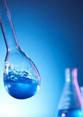 Mavi sıvılı laboratuvar şişesi.