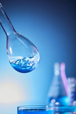 Mavi sıvılı laboratuvar şişesi.