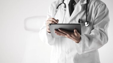 Hastane ofisindeki masada steteskoplu bir doktor. Sistematik sağlık yönetimi için bir doktora danışıyorum..