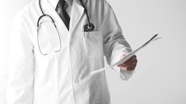 Hastane ofisindeki masada steteskoplu bir doktor. Sistematik sağlık yönetimi için bir doktora danışıyorum..