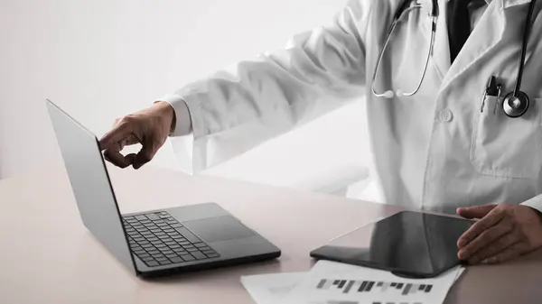 Hastane ofisindeki masada steteskoplu bir doktor. Sistematik sağlık yönetimi için bir doktora danışıyorum..