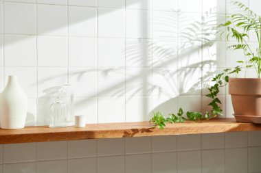 Duvarı ve beyaz fayansları olan beyaz ahşap bir raf. Sıcak güneş ışığı ve doğa tarafından kucaklanan huzurlu bir yer. Uyum, konfor ve zarif güzelliğin bir araya geldiği yer..