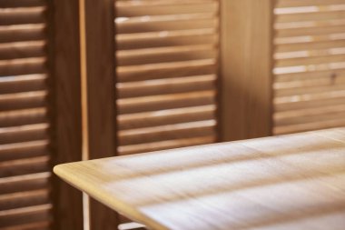 Sıcak ahşap bir iç mekanda güneş ışığı ve gölgeler..