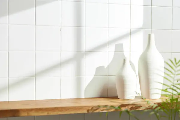 Duvarı ve beyaz fayansları olan beyaz ahşap bir raf. Sıcak güneş ışığı ve doğa tarafından kucaklanan huzurlu bir yer. Uyum, konfor ve zarif güzelliğin bir araya geldiği yer..