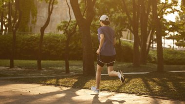 Güneşli bir günde açık havada koşma rutini. Hareketli Motivasyon. Fitness Yolculuğunuza Başlayın.