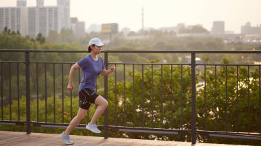 Güneşli bir günde açık havada koşma rutini. Hareketli Motivasyon. Fitness Yolculuğunuza Başlayın.