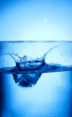 Bardağın arka planına su sıçrıyor.