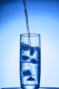 Mavi arka planda bir bardak su