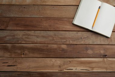Ahşap arka planda boş bir defter. düz üst görünüm.