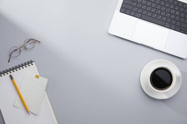 Laptop bilgisayarı ve masada bir fincan kahve olan bir iş yeri..