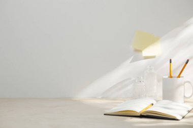 Boş bir kitap, beyaz boş bir sayfa ve beyaz arka planda beyaz kahve fincanı olan bir lamba. eğitim ve öğrenme kavramı