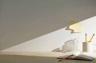 Boş defter, kitaplar ve kalem beyaz masada..