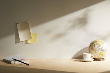 Modern işyeri. Beyaz duvarda dizüstü bilgisayarı, küresi ve lambası olan çalışma alanı