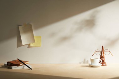 Masanın üzerinde boş defter ve gözlük var.