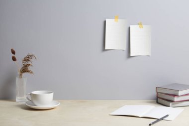 Boş kağıt, not defteri ve kalem masanın üzerinde.