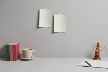 Gri arka planında bilgisayar, kitap ve lamba olan modern işyeri. İşiniz için model alın.