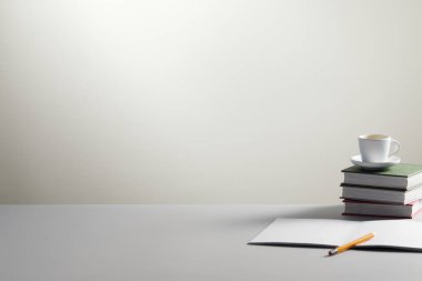 Bir yığın kitap ve kahve fincanı.