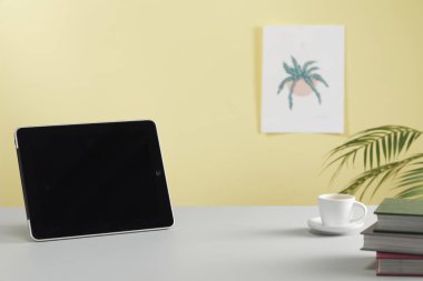Boş ekranlı modern tablet ve pencerenin yanındaki masada kahve fincanı. ev dekoru