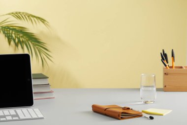 Ofisteki beyaz ahşap masada bilgisayar, kırtasiye ve bir fincan kahve olan işyeri.