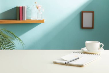 Boş defter, kupa ve bitki dolu modern işyeri.