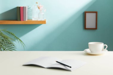 kahve fincanı ve defter masanın üstünde.