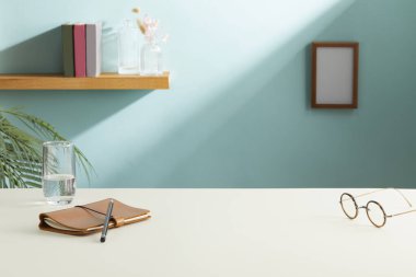 Bilgisayarlı şık bir iş yeri, duvarın yanındaki masada kırtasiye malzemesi. Metin için boşluk