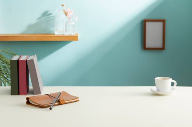 Modern işyeri, kahve fincanı ve kitap ofisteki masada.