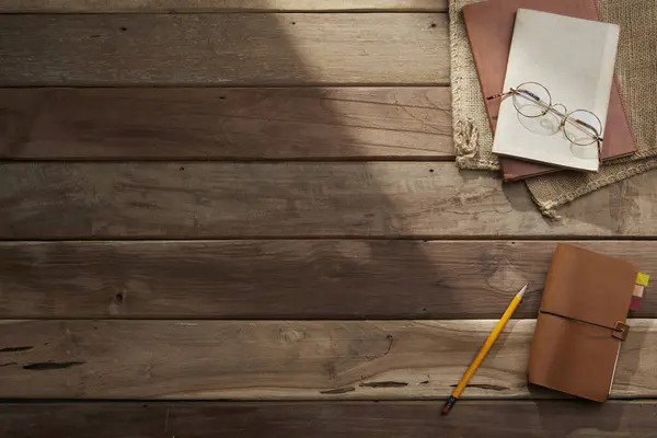 defter, gözlük ve kalem kopya alanı olan ahşap masa üzerinde..