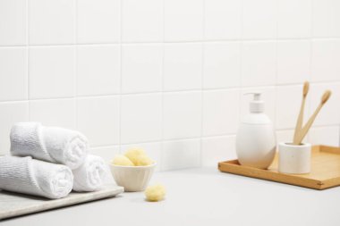 Banyodaki masada banyo malzemeleriyle birlikte temiz havlu ve sabun var..