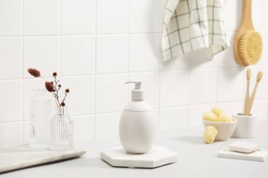 Temiz çamaşır makinesi. Tuğla duvarın yanındaki masada sabun ve havlu var..