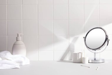 ışık arka planında kozmetik ürünleri olan ayna.