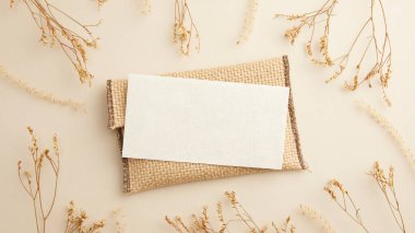 Çarşaf peçetede boş bir kağıt bir çiçek ve bir dal pamuk.