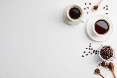 Beyaz arka planda kahve çekirdekli kahve ve mesaj için yer. Üst Manzara. Boşluğu kopyala.