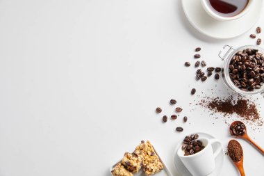 Bir fincan kahve, fasulye, şeker, tarçın ve kahve çekirdeği beyaz arka planda fotokopi alanı ile. Üst Manzara. düz yat.