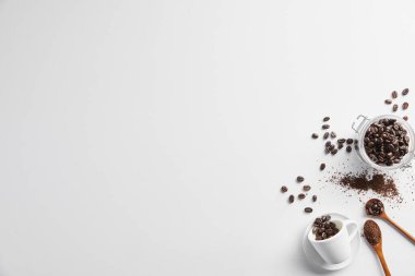 Beyaz arka planda kahve çekirdekleri ve kahve fincanı..