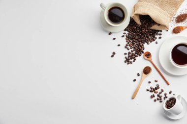 Beyaz arka planda siyah kahve, fasulye ve tarçın çubukları ile kompozisyon
