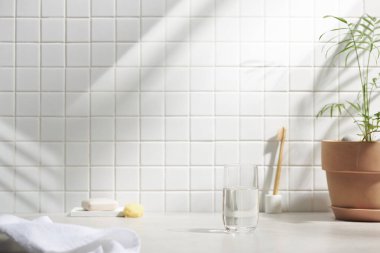 Beyaz seramik zemin üzerinde çeşitli nesneler ve sıcak güneş ışığı içinden geçiyor..