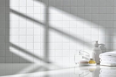 Beyaz seramik zemin üzerinde çeşitli nesneler ve sıcak güneş ışığı içinden geçiyor..