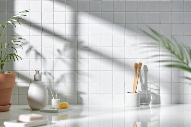 Beyaz seramik zemin üzerinde çeşitli nesneler ve sıcak güneş ışığı içinden geçiyor..