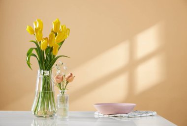 Pencerelerden süzülen güneş ışığı ve taze çiçeklerle dolu rahat bir ev.