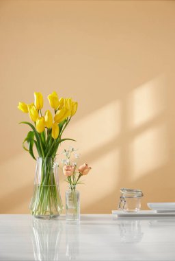 Pencerelerden süzülen güneş ışığı ve taze çiçeklerle dolu rahat bir ev.