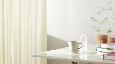 Bu odada doğal ışık ile sakin bir atmosfer var. Masada kil kaplar, cam şişeler, kahve ve çeşitli maddeler var..