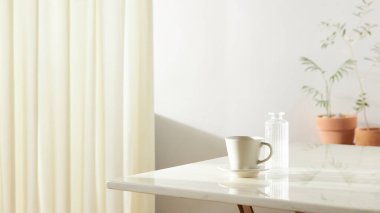 Bu odada doğal ışık ile sakin bir atmosfer var. Masada kil kaplar, cam şişeler, kahve ve çeşitli maddeler var..